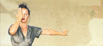 Female dancer holding one hand before right eye