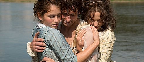 Ein Mann wird von zwei Frauen innig umarmt