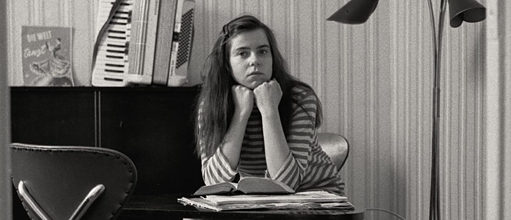 Ursula, die Hauptfigur des Films, sitzt mit einem Buch am Tisch