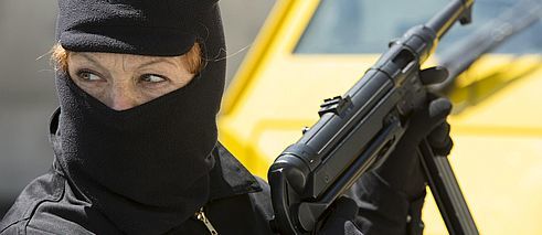 Frau mit Sturmmütze und Waffe