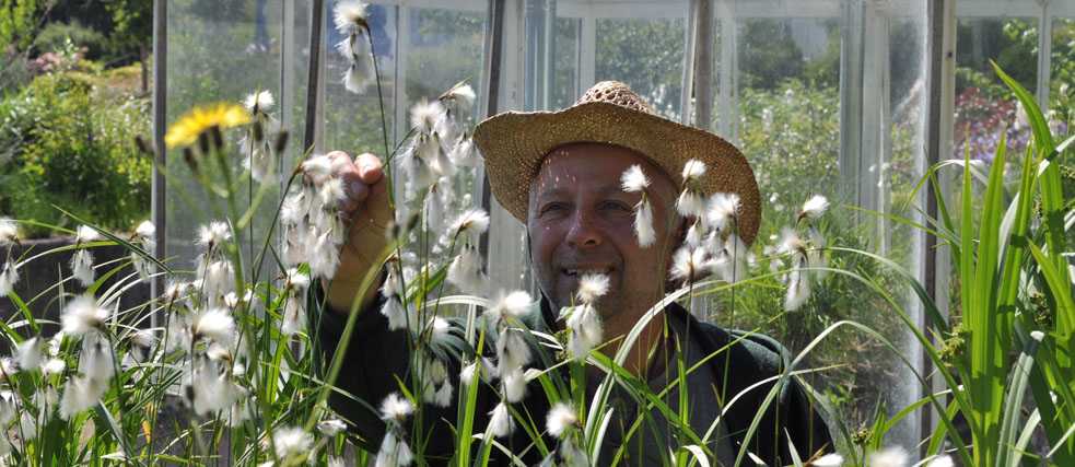 Gärtner Thomas Heller schaut sich Pflanzen im Botanischen Garten an.