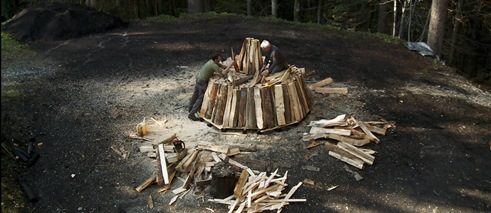 Pure Charcoal, film still: two men are stacking firewood
