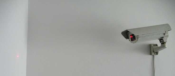 CCTV Kamera, die einen roten Punkt an die Wand beamt