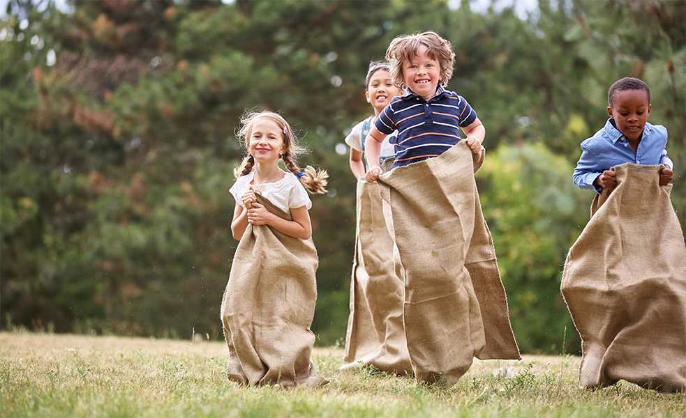 Lors de la course en sac, les enfants sautillent pour atteindre la ligne d’arrivée 