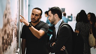 The artist Osama Byala talking to a visitor