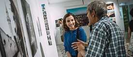 Journalist and photographer Heba Alshibani standing with a visitor