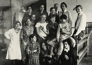 Skupinová fotka tkáčskej triedy pod vedením Gunty Stölzl (s kravatou) okolo roku 1927. 