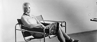 Moteris, sėdinti Marcelio Breuerio sukurtame gembiniame krėsle iš tuščiavidurių plieno profilių, 1926.