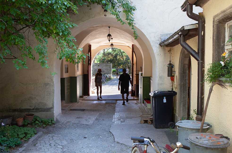 Eine steinerne Brücke führt vom Schlosshof hinaus auf das Gelände. Rund 30 Hektar umfasst das gesamte Gemeinschaftsgrundstück, zu dem weitere Gebäude, Felder, Streuobstwiesen, Weiden und Wälder gehören. Teile davon stehen unter Naturschutz. 