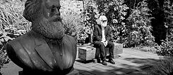 Michael Thielen como Karl Marx Double em Trier, sentado no jardim do Museu Karl-Marx-Haus