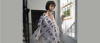 Un jeune homme est enveloppé dans un vêtement composé d'étiquettes Europe or die