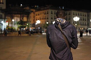 رجل، عمر، يواجه ساحة الشهداء الخاوية، الجزائر العاصمة، في إحدى ليالي شهر رمضان.