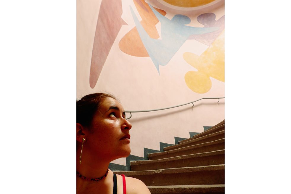  <b>Ginna Alejandra Vélez Carrasco</b>, kolumbianische Künstlerin und Dozentin, Bauhaus-Universität Weimar: Ich stieß auf das Bauhaus und seinen Beitrag zur Kunstpädagogik, während ich, ausgehend von einer Performance, an meiner Abschlussarbeit über die Konsumgesellschaft arbeitete. Die Bauhaus-Bewegung betont die gemeinschaftliche Arbeit und die Vereinigung der Kunst mit anderen Disziplinen auf eine objektive und funktionale Weise. Durch die Transdisziplinarität werden kontinuierliche Denkprozesse über die Rolle der Kunst im sozialen Kontext und ihre Zugänglichkeit unabhängig von Geschlecht, Nationalität, Alter oder finanziellem Status in Gang gesetzt. In Kolumbien hat das Bauhaus Fragen zur Lehre der Künste ausgelöst. Ich habe in Weimar studiert, um mich wieder zu finden und zu verbinden mit einem Teil der Geschichte dessen, was ich heute bin: Kunstdozentin und Performerin. <br><br>  <b>Foto:</b> Van-de-Velde-Bau, Bauhaus-Universität Weimar, 2015. Die Wandmalerei Oskar Schlemmers entstand 1923 und steht für seine Hinwendung zur Erforschung des Körpers, zur Bewegung und den szenischen Künsten. Schlemmer hat mitbeeinflusst, dass ich in Weimar leben wollte.