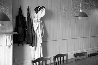 A bee suit next to aprons on the wall at Orphans Kitchen