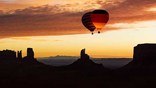 Trotz rauer Winde über dem Monument Valley starten die zwei Heißluftballons in den Sonnenaufgang.