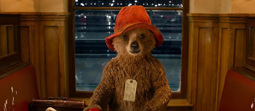Un ours qui porte un chapeau rouge et une étiquette autour du cou.