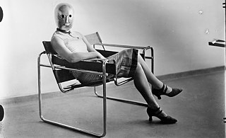 Woman sitting in Marcel Breuer tubular steel chair, 1926. 