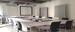 Salle de réunion équipée d’un tableau blanc mural et d’un vidéoprojecteur