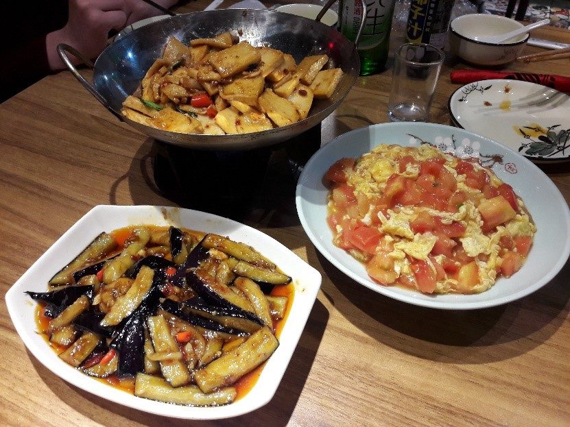 Gebratene Aubergine (mein Favorit), Eier mit Tomate und Tofu. Alle Gerichte stehen in der Mitte des Tisches und werden geteilt.