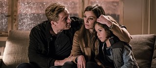 Still from You Are Wanted – Family meeting in the living room: the Franke family huddled on their sofa discussing how to leave Germany