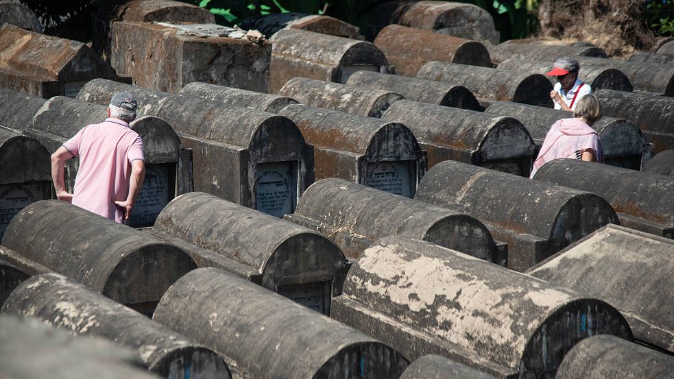 Visitors walk through Yangon's Jewish cemetery in search for the graves of their ancestors. 
