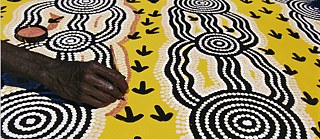 Der australische Aborigine-Künstler Turkey Tolson Tjupurrula bei der Arbeit