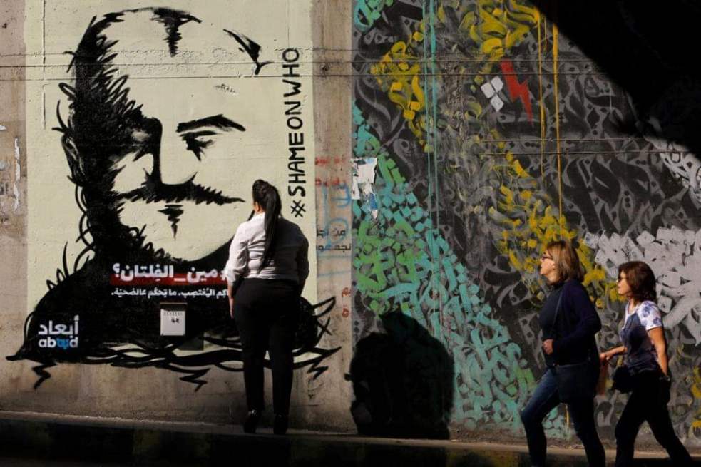 Eine Frau betrachtet ein Graffiti mit dem Gesicht eines beschuldigten Vergewaltigers mit dem Hashtag „Shame on Who“ – Schande über wen?