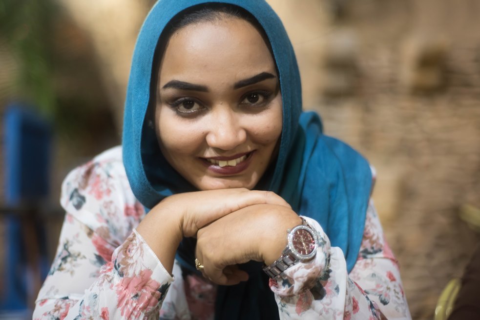 Image of the photographer, Eythar Gubara, a young muslim woman smiling at the camera.