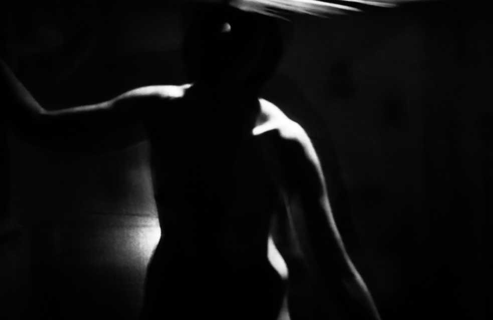 Blurred black and white photo of a nude woman.