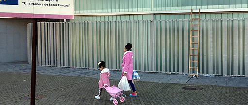 Mutter mit kleinem Mädchen ganz in rosa laufen auf dem Gehweg in Sevilla
