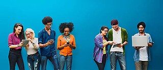 Young people of different nationalities looking at tablets, smartphones or laptops.