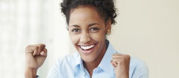 A young woman clenching her fists in joy.