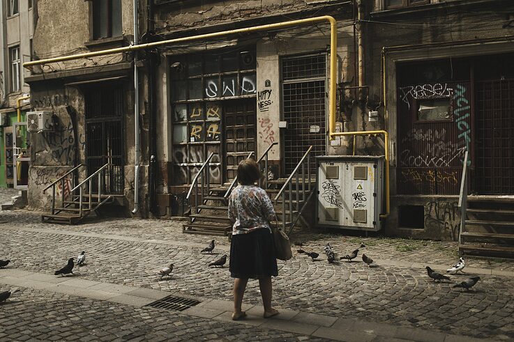 Eine Frau, die in der Altstadt von Bukarest Vögel füttert.
