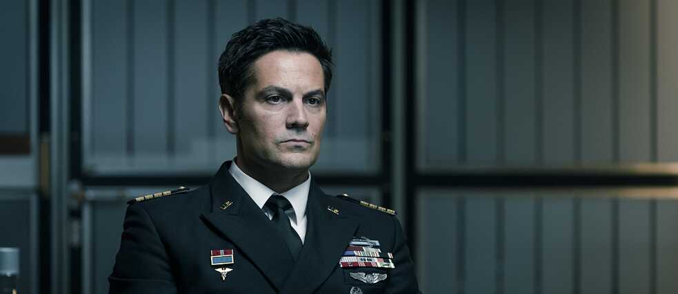 Still from You are Wanted - Temporada 2, Episodio 1 No hay compromisos: El Almirante Bruce Gardner está cazando a Luke Franke.  