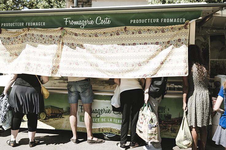 Menschen kaufen frische Produkte aus ökologischer Landwirtschaft auf einem Wochenmarkt. 