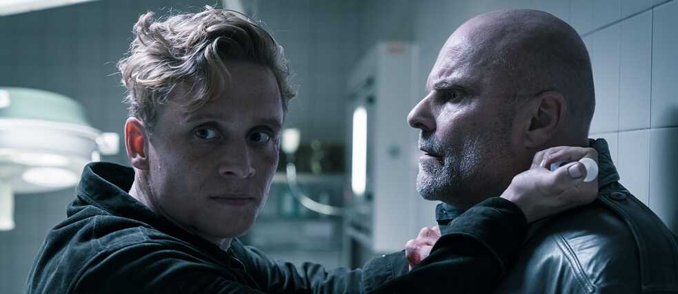 still from You Are Wanted – Season 2, Episode 1: Going berserk: Lukas threatens the BND agent Wakura with a syringe