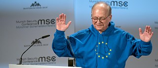 Wolfgang Ischinger draagt tijdens een lezing een blauw sweatshirt met capuchon, waarop de sterren van de Europese vlag zijn afgebeeld.