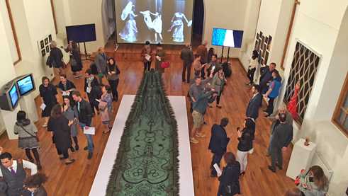 In the background is a video installation by the Brazilian artist André Severo. 