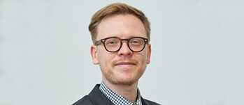Porträt von Markus Gabriel, stehend mit Brille