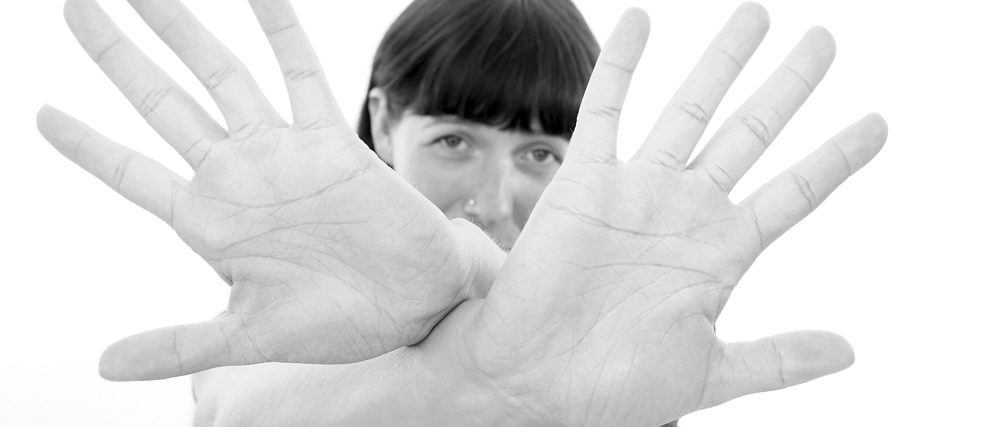 A woman cups hands in front of her face