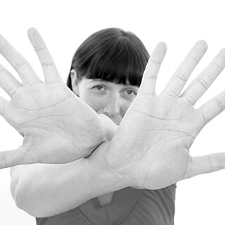 A woman cups hands in front of her face