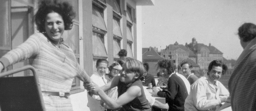 Gymnastics teacher Karla Grosch, who played a key role in the performances of the drama class, jokes with students on the terrace in front of the Bauhaus canteen