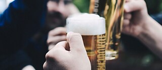 Freunde stoßen mit einem Bier an