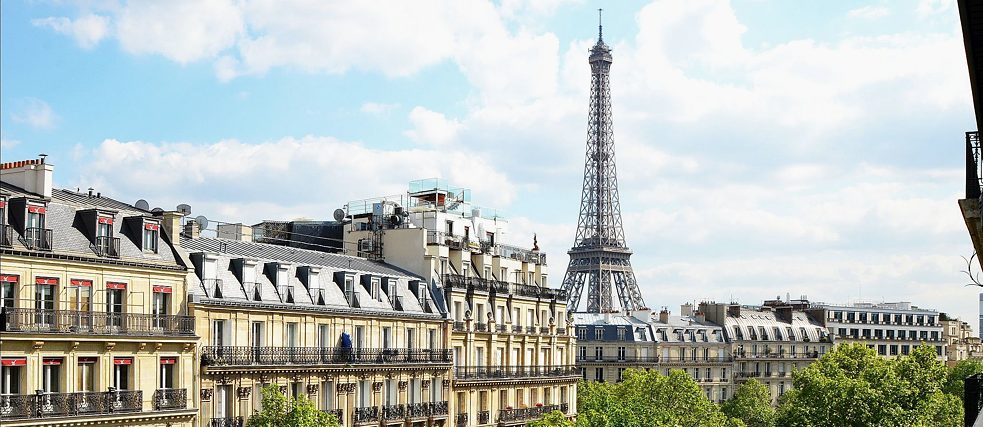 <b>Goethe-Institut Paris (Paris, France)</b><br> <br>Difficile à croire : on peut admirer cette vue depuis le balcon du quatrième étage de l'immeuble Iéna du Goethe-Institut à Paris. Voir la Tour Eiffel au-dessus des toits de Paris fait battre beaucoup de cœurs plus vite. Les toits en zinc gris-bleu donnent à Paris son charme incomparable. Depuis le milieu du XIXe siècle, le « style haussmannien » prédomine dans le paysage architectural de Paris.