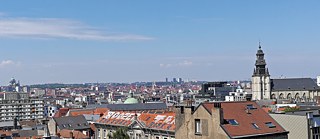 <b>Brüsseler Marollen (Brüssel, Belgien)</b><br><br>An einem sonnigen Freitag blicken wir über die Dächer der Marollen, dem Brüsseler Arbeiterviertel. In der Ferne können wir auf einige Sehenswürdigkeiten wie die Basilika von Koekelberg, das größte Art Deco Gebäude der Welt, sowie auf die Kirche „Église Notre-Dame de la Chapelle“ blicken. In der Nähe der Kirche wohnte und arbeitete Pieter Bruegel der Ältere, zu dessen Ehren in diesem Jahr das Bruegel-Jahr mit vielen Kulturveranstaltungen organisiert wird.  Bei genauerem Hinsehen kann man in der Ferne auch das Brüsseler Wahrzeichen, das Atomium, entdecken.