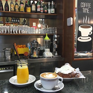 <b>Petit déjeuner au bar (Rom, Italie)</b><br><br>Un cappuccino, du jus d'orange fraîchement pressé et un "Maritozzo" à la crème : un petit déjeuner romain irrésistible dans un bar typique. La meilleure façon de commencer sa journée !