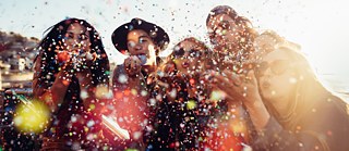 Eine Gruppe junger Leute feiert und wirft Konfetti