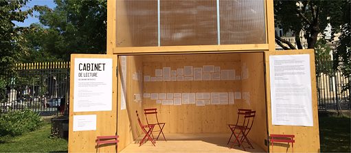 Cabinet de lecture ouvert, fait de bois, avec des chaises rouges, dans un parc