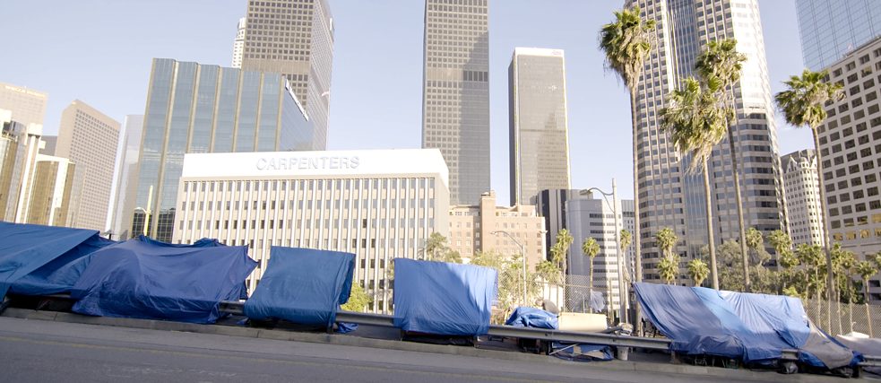 Planen zwischen einem Zaun und einer Leitplanke in Los Angeles