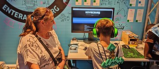 At the Enter Africa stand in the Indie Arena Booth: A boy and his mother playing the Voyageurs game by Enter Africa members from Cameroon